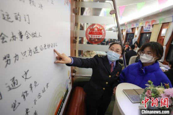 贵阳客运段职工林晓斐在“列车书吧”给学生旅客介绍推荐书单。　瞿宏伦 摄