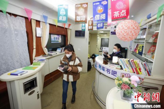 一位学生旅客在Z150次列车“列车书吧”内借阅书籍。　瞿宏伦 摄