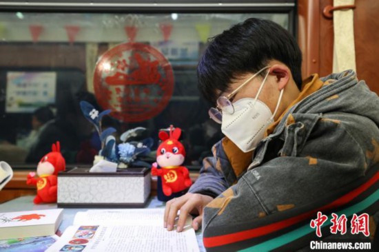 一位来自贵州毕节的学生旅客在“列车书吧”阅读书籍。　瞿宏伦 摄
