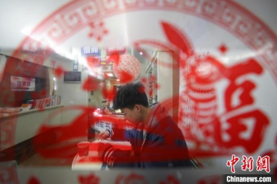 一位学生旅客在“列车书吧”阅读书籍。　瞿宏伦 摄