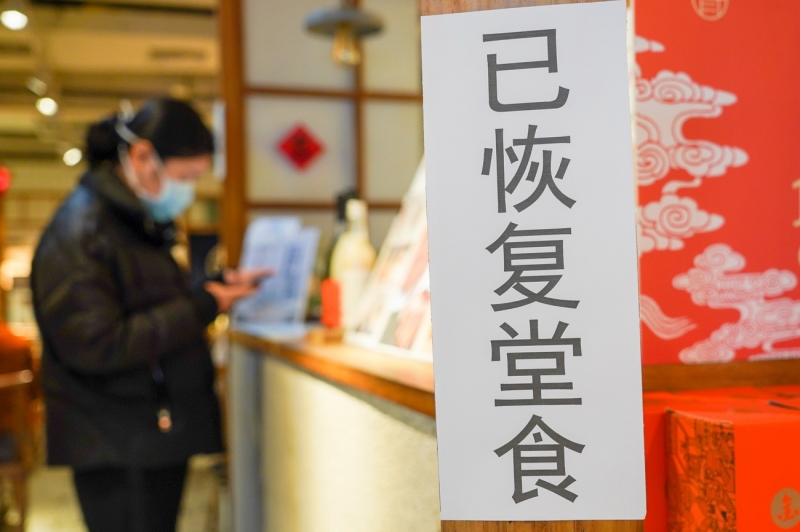 3月9日，在南京新街口商圈，一家饭店入口处贴有“已恢复堂食”的标牌。